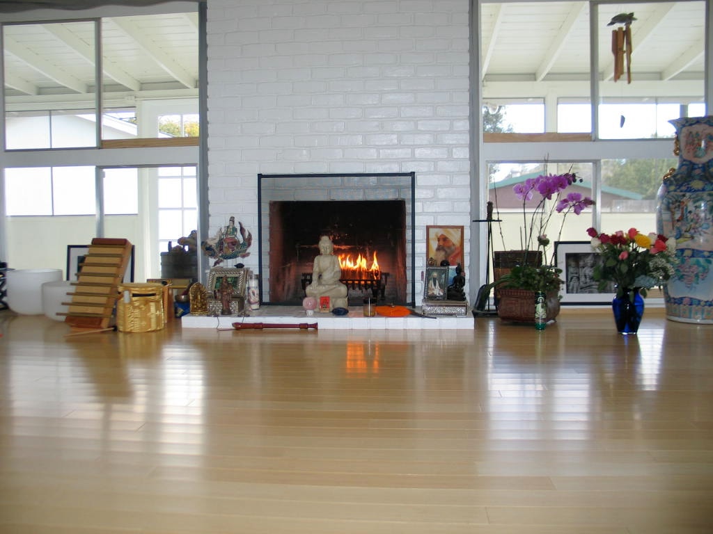 Studio sanctuary with a white brick fireplace and meditation decor
